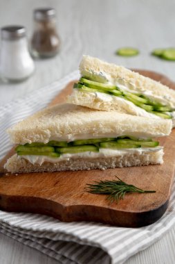 Homemade English Cucumber Sandwiches on a rustic wooden board, low angle view. Close-up.