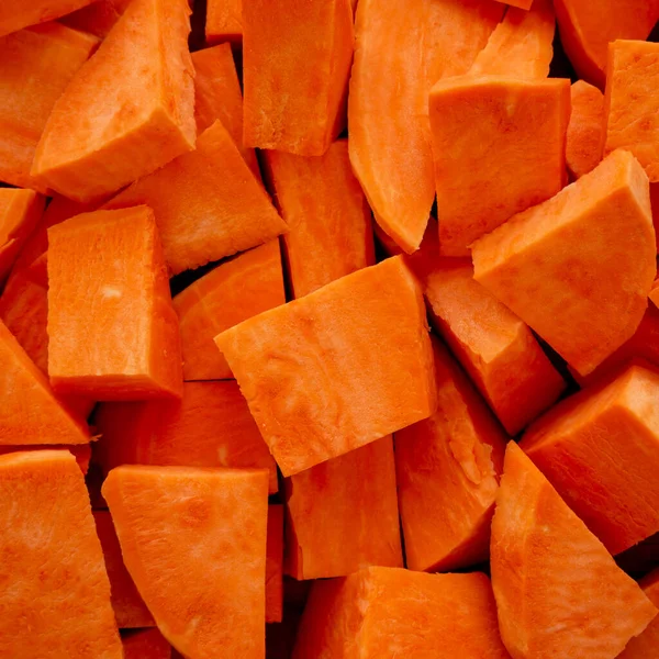 stock image Raw Chopped Sweet Potatoes on a Cutting Board, top view. Flat lay, overhead, from above. 