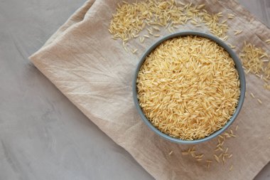 Kuru organik Hint Basmati Rice 'ı gri arka planda bir kasede, üst manzara. Boşluğu kopyala.