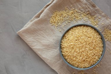 Kuru organik Hint Basmati Rice 'ı gri arka planda bir kasede, üst manzara. Metin için boşluk.