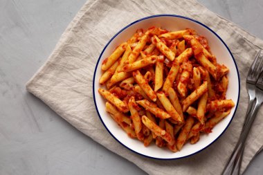 Tabakta domates soslu ev yapımı Penne, en iyi manzara. Yukarıdan, yukarıdan, dümdüz. Boşluğu kopyala.