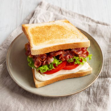 Tabakta ev yapımı BLT Sandviç (Pastırma, Marul ve Domates), yan görünüm. 