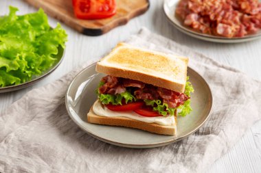 Tabakta ev yapımı BLT Sandviç (Pastırma, Marul ve Domates), yan görünüm. 