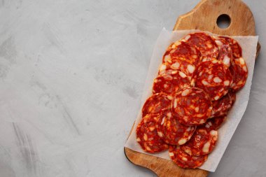 İspanyol sucuklu salam sosisi. Kırsal ahşap bir tahta üzerinde. Gri bir arka plan, üst manzara. Dümdüz, tepeden, yukarıdan.