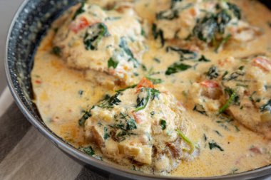 Homemade Creamy Tuscan Chicken with Spinach in a Pan, side view. Close-up. clipart