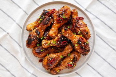 Ev yapımı Kolay Yapışkan Tavuk Davul Çubuğu Tabakta, üst manzara. Yukarıdan, dümdüz uzanmış.