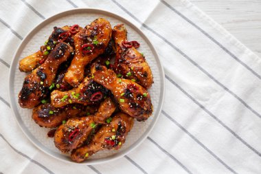 Ev yapımı Kolay Yapışkan Tavuk Davul Çubuğu Tabakta, üst manzara. Yukarıdan, dümdüz uzanmış.