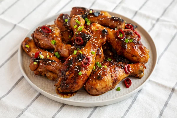 Homemade Easy Sticky Chicken Drumsticks on a Plate, side view.
