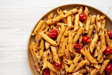 Beyaz ahşap zemin üzerinde, ev yapımı ıspanak ve domates soslu makarna. Dümdüz, tepeden, yukarıdan. 