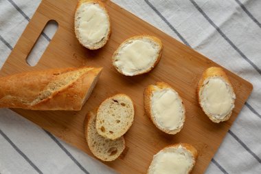 Bambu tahtasında ev yapımı ekmek ve tereyağı, üst manzara. Dümdüz, tepeden, yukarıdan.