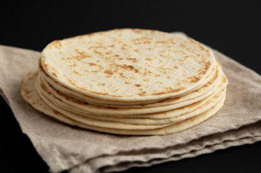 Siyah arka planda bir yığın Buğday unu Tortillası, yan görüş. Yakın plan..