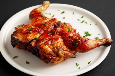 Ev yapımı Spatchcocked Izgara Piri-Piri Tavuğu Maydanozlu, yan manzaralı.