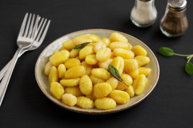 Siyah arka planda bir tabakta ev yapımı Kolay Patates Gnocchi..