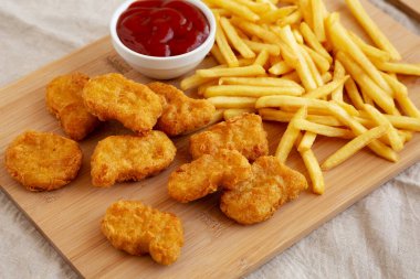 Tavuk nugget ve ketçaplı patates kızartması yemeye hazır. Yakın plan.