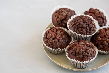 Tabakta ev yapımı Dark Chocolate Muffins, yan görüş. Boşluğu kopyala.