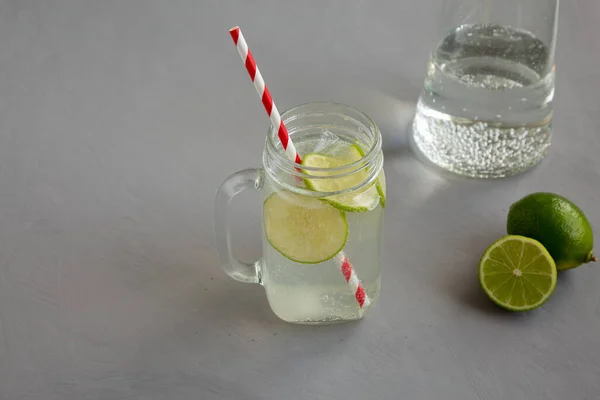 Cold Indian Nimbu Soda in a Glass Jar on a gray background, side view.