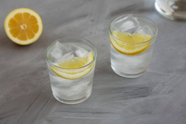 Gözlüklü Lemon ile Soğuk Su Gri arka planda, yan görünümde tazeleniyor.