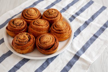 Beyaz ahşap arka planda ev yapımı tarçınlı çörek. Yakın plan..