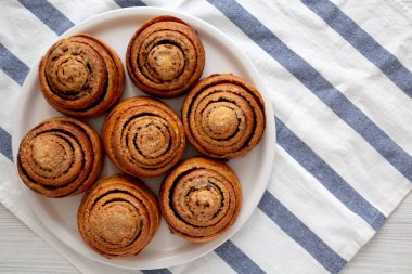 Beyaz ahşap arka planda ev yapımı tarçınlı çörek. Dümdüz, tepeden, yukarıdan. Boşluğu kopyala.