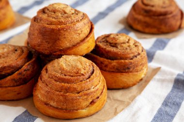 Beyaz ahşap arka planda ev yapımı tarçınlı çörek. Yakın plan..