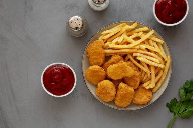 Ev yapımı tavuk nugget ve ketçaplı patates kızartması. Dümdüz, tepeden, yukarıdan. Boşluğu kopyala.