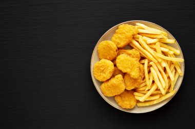 Ev yapımı tavuk nugget ve ketçaplı patates kızartması. Dümdüz, tepeden, yukarıdan. Boşluğu kopyala.