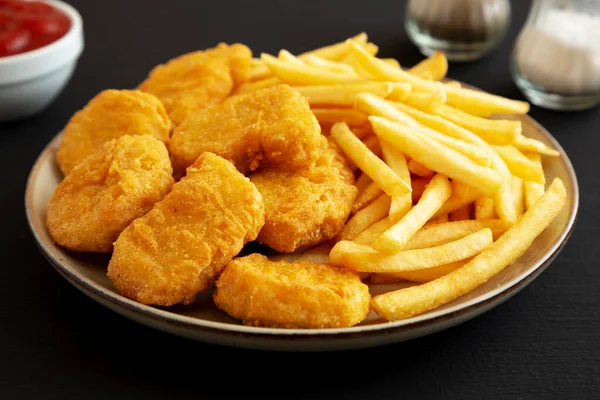 stock image Homemade Chicken Nuggets and French Fries with Ketchup on black background, side view. Close-up.