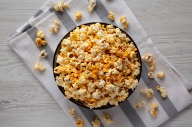 Beyaz ahşap arka planda peynirli ev yapımı patlamış mısır. Dümdüz, tepeden, yukarıdan.