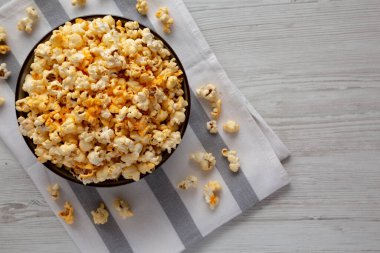 Beyaz ahşap arka planda peynirli ev yapımı patlamış mısır. Dümdüz, tepeden, yukarıdan. Boşluğu kopyala.