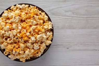 Beyaz ahşap arka planda peynirli ev yapımı patlamış mısır. Dümdüz, tepeden, yukarıdan. Boşluğu kopyala.