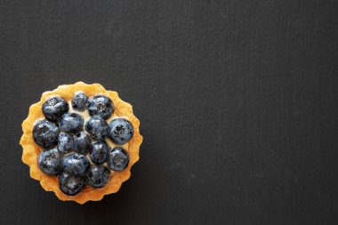 Siyah arka planda yabanmersinli tart, üst manzara. Dümdüz, tepeden, yukarıdan.