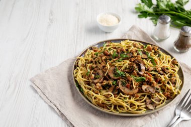 Tabakta ev yapımı mantar, ıspanaklı ve sosisli spagetti..