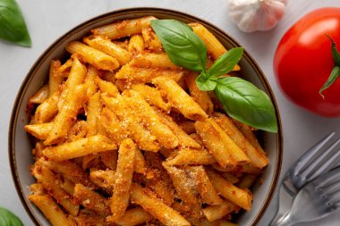 Peynirli ve fesleğenli ev yapımı domates pesto makarna. Dümdüz, tepeden, yukarıdan. Yakın plan..
