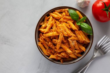 Peynirli ve fesleğenli ev yapımı domates pesto makarna. Dümdüz, tepeden, yukarıdan. Boşluğu kopyala.