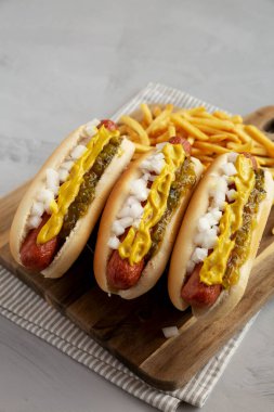 Hardallı, soğanlı ve turşulu ev yapımı sosisli sandviçler ahşap bir tahtanın üzerinde.. 