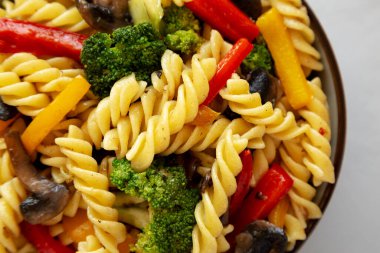 Ev yapımı sarımsaklı sebzeli makarna, gri arka planda, üst manzara. Dümdüz, tepeden, yukarıdan.