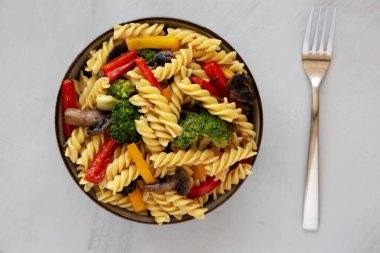 Ev yapımı sarımsaklı sebzeli makarna, gri arka planda, üst manzara. Dümdüz, tepeden, yukarıdan.