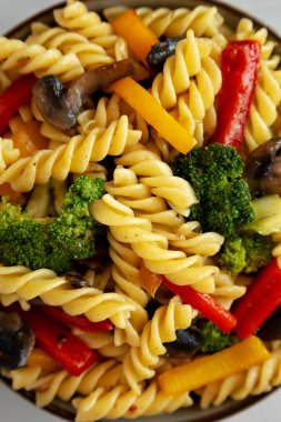 Ev yapımı sarımsaklı sebzeli makarna, gri arka planda, üst manzara. Dümdüz, tepeden, yukarıdan.