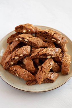 Ev yapımı İtalyan Cantuccini, yanında Almond ve Kahve ile gri bir tabakta, kenar manzaralı. Çıtır badem ve kahve kurabiyeleri..