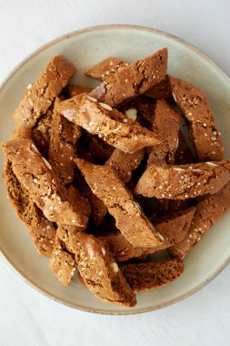 Ev yapımı İtalyan Cantuccini, yanında Almond ve Kahve ile gri bir tabakta, kenar manzaralı. Çıtır badem ve kahve kurabiyeleri..