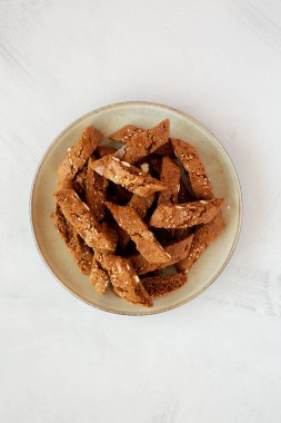 Ev yapımı İtalyan Cantuccini, yanında Almond ve Kahve ile gri bir tabakta, kenar manzaralı. Çıtır badem ve kahve kurabiyeleri..