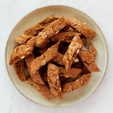 Ev yapımı İtalyan Cantuccini, yanında Almond ve Kahve ile gri bir tabakta, kenar manzaralı. Çıtır badem ve kahve kurabiyeleri..