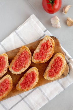 Ev yapımı Pan Con Tomate (Domates tostu) bir tahta üzerinde, üst manzara. Yukarıdan, yukarıdan, dümdüz. Boşluğu kopyala.