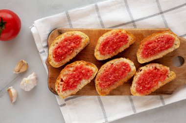 Ev yapımı Pan Con Tomate (Domates tostu) bir tahta üzerinde, üst manzara. Yukarıdan, yukarıdan, dümdüz.
