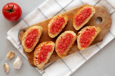 Ev yapımı Pan Con Tomate (Domates tostu) bir tahta üzerinde, üst manzara. Yukarıdan, yukarıdan, dümdüz.