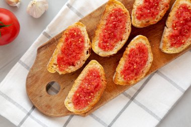 Ev yapımı Pan Con Tomate (Domates tostu) bir tahta üzerinde, üst manzara. Yukarıdan, yukarıdan, dümdüz. 