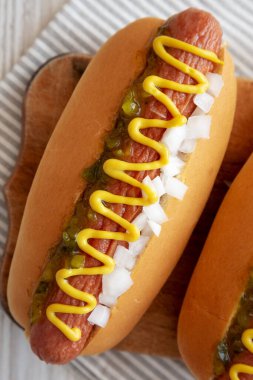 Hardallı, çeşnili ve soğanlı ızgara sosisli, ahşap bir tahtanın üstünde.. 