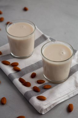 Gözlüklü organik beyaz badem sütü, yan görünüm. 