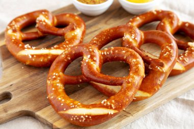 Tahta üzerinde hardal olan ev yapımı yumuşak Bavyera krakerleri..