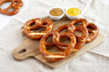 Tahta üzerinde hardal olan ev yapımı yumuşak Bavyera krakerleri..